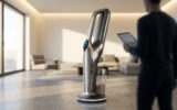 Suceuse-balai futuriste dans un salon moderne. Un homme consulte une tablette affichant 'TOP RATED' et 5 étoiles, symbolisant son succès.