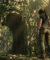 Lara Croft debout de dos devant une arche de pierre ancienne recouverte de végétation dans une jungle luxuriante.