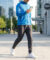 Un homme en veste bleue marche en ville en consultant son itinéraire sur son smartphone.