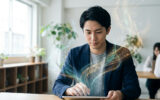 Un jeune homme en costume travaille sur une tablette d'où s'échappent des flux de lumière abstraits et des symboles.