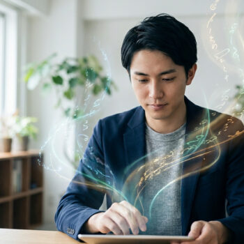 Un jeune homme en costume travaille sur une tablette d'où s'échappent des flux de lumière abstraits et des symboles.