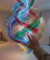 Une main tendue vers une sculpture lumineuse en spirale dans une galerie d'art, entre ruines antiques et écran futuriste.