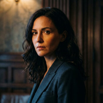 Portrait de l'actrice Hannah Gross regardant intensément l'objectif dans un décor sombre et boisé.