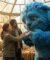 Ryan Reynolds et une jeune fille interagissent avec Blue, une grande créature bleue poilue dans une serre.