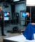 Un homme en costume et une femme en robe bleue sur le plateau technique d'une émission de télévision.