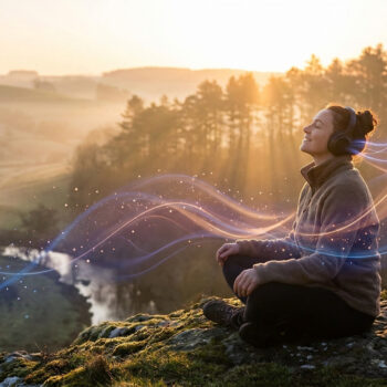 Une femme assise sur un rocher en pleine nature, écoutant de la musique avec des ondes lumineuses autour d'elle au coucher du soleil.