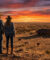 Un couple en tenues de cow-boy contemple un ranch au Texas sous un spectaculaire coucher de soleil.