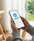 Une personne tient un smartphone affichant une application de messagerie avec une icône de bouclier de sécurité.