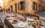 Table dressée avec des plats méditerranéens dans une rue piétonne animée du Vieux-Nice.