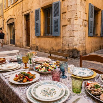 Table dressée avec des plats méditerranéens dans une rue piétonne animée du Vieux-Nice.